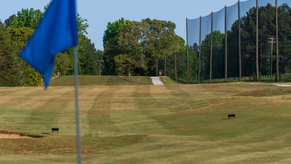 close up of blue flag with fairway in the background