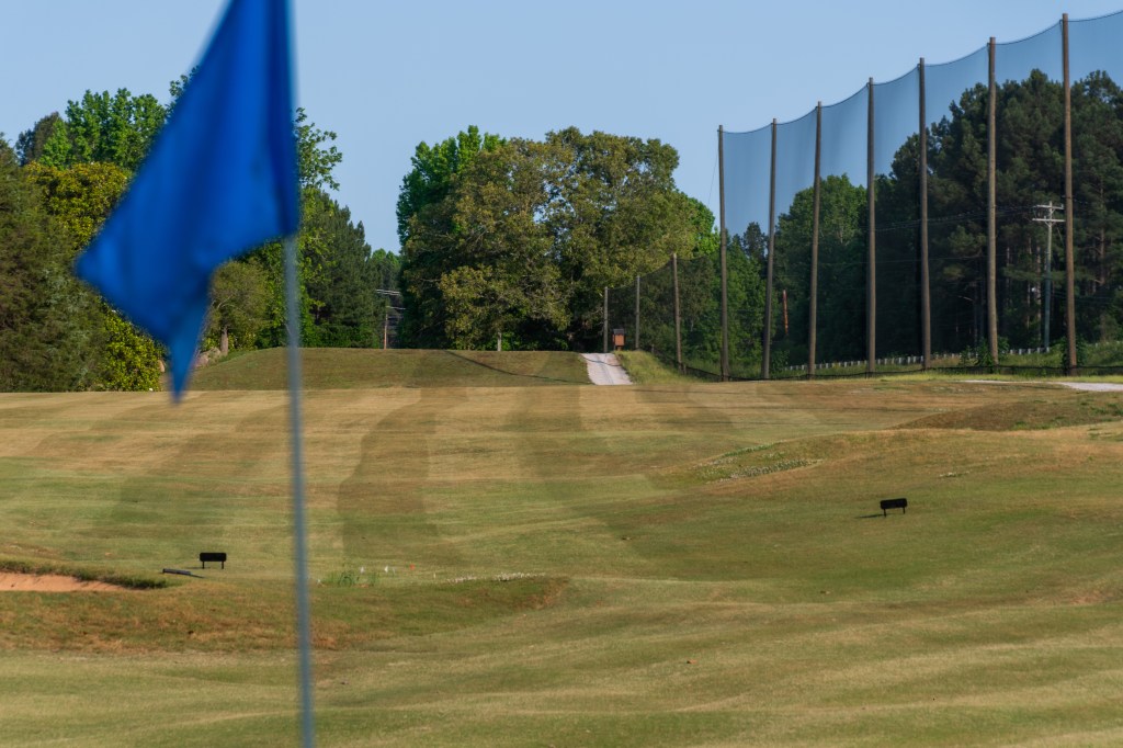 close up of blue flag with fairway in the background